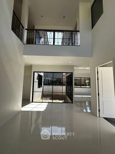 Spacious modern living room with high ceilings and large windows for natural light.