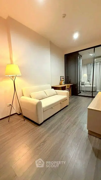 Modern living room with sleek flooring and cozy lighting, featuring a stylish sofa and elegant decor.