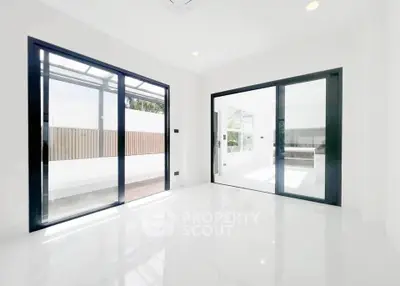 Bright modern room with large sliding glass doors and white marble flooring, perfect for natural light lovers.