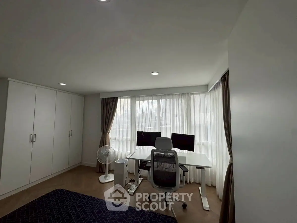 Modern home office with dual monitors and ergonomic chair in bright room
