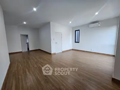 Spacious modern living room with wooden flooring and air conditioning