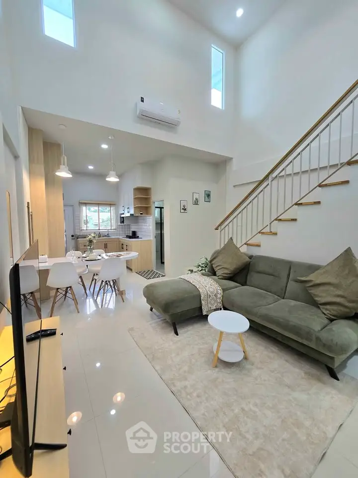 Modern living room with high ceiling and stylish decor in a contemporary home.