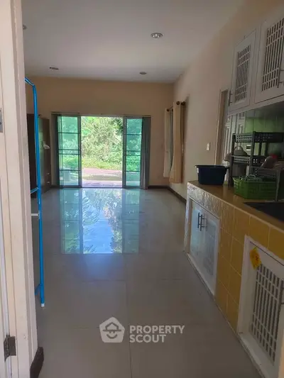 Spacious living area with large windows and garden view, perfect for natural light lovers.