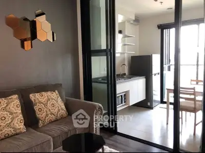 Modern living room with open kitchen and dining area, featuring stylish decor and ample natural light.