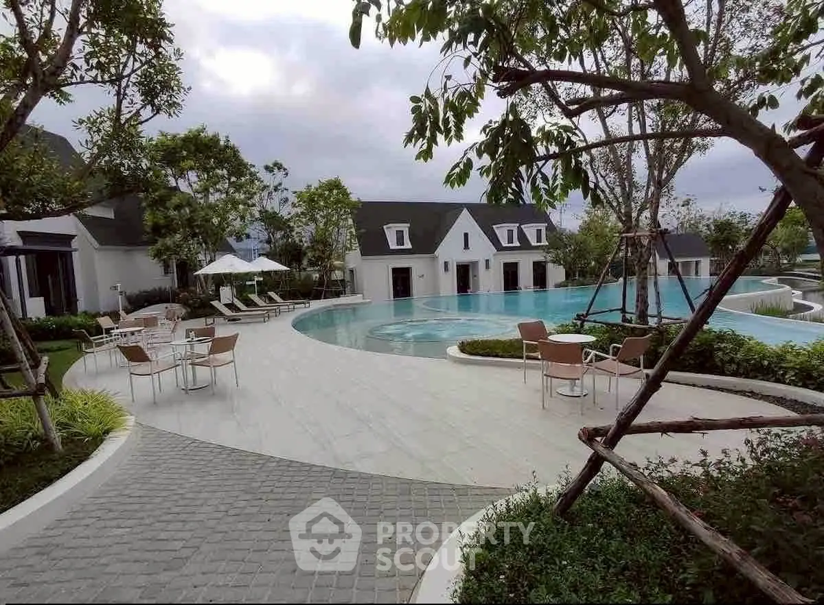 Luxurious poolside view with elegant seating and lush greenery, perfect for relaxation and leisure.