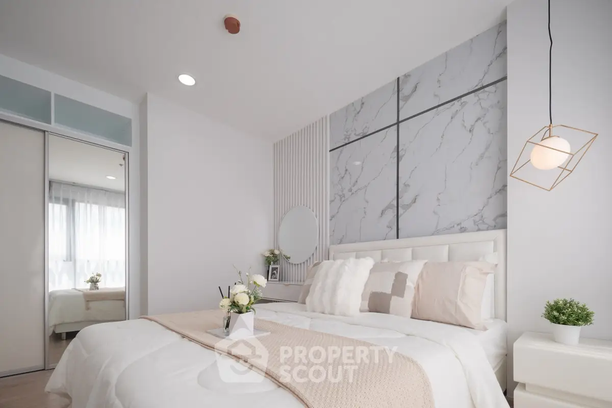 Modern bedroom with elegant decor and marble accent wall, featuring cozy bedding and stylish lighting.