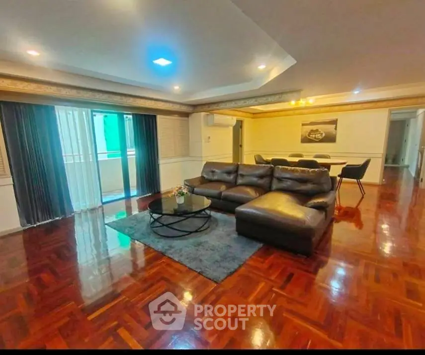 Spacious living room with elegant wooden flooring and modern furniture in a luxurious apartment.