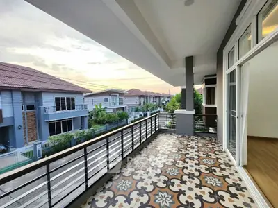 Spacious balcony with decorative tiles and scenic neighborhood view.
