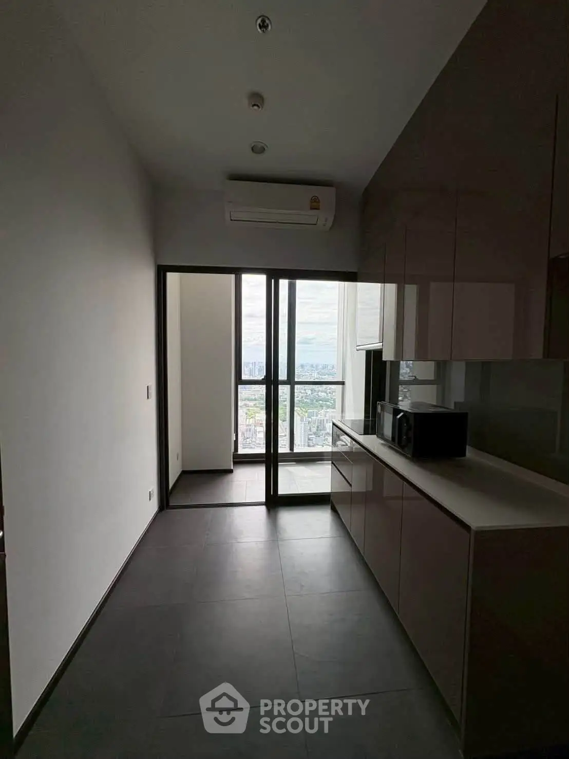Modern kitchen with sleek cabinetry and city view from balcony, perfect for urban living.