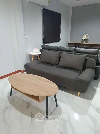 Modern living room with sleek furniture and marble flooring, featuring a stylish sofa and coffee table.
