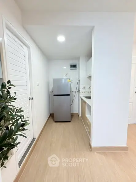 Modern kitchen with sleek fridge and minimalist design in a bright apartment.