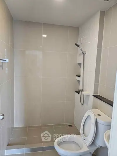 Modern bathroom with sleek tiles and shower in a contemporary home.