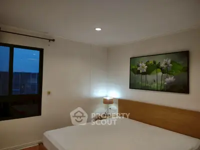 Cozy bedroom with modern decor and large window for natural light.