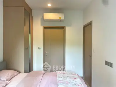 Cozy bedroom with modern air conditioning and soft pastel bedding, perfect for relaxation.