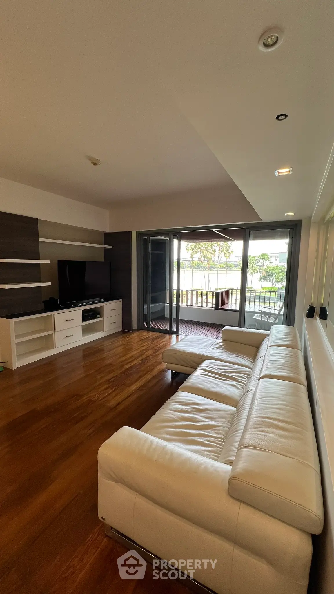 Spacious living room with modern furniture and large balcony access, perfect for relaxation and entertainment.
