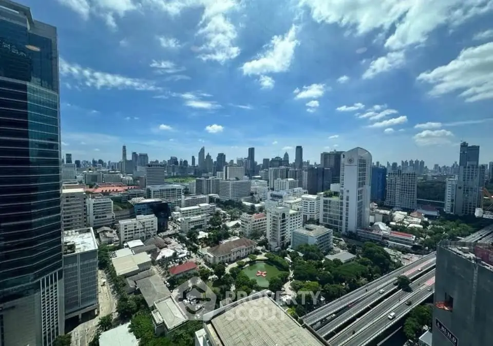 Stunning cityscape view from high-rise building with clear blue sky and urban skyline.