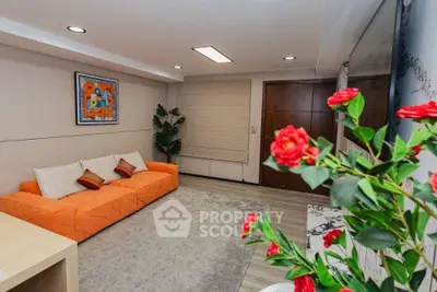 Stylish living room with vibrant orange sofa and modern decor, perfect for relaxation and entertaining.