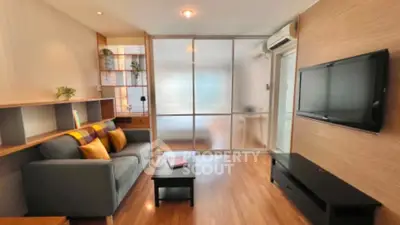Modern living room with sleek design and wooden flooring, featuring a cozy sofa and wall-mounted TV.