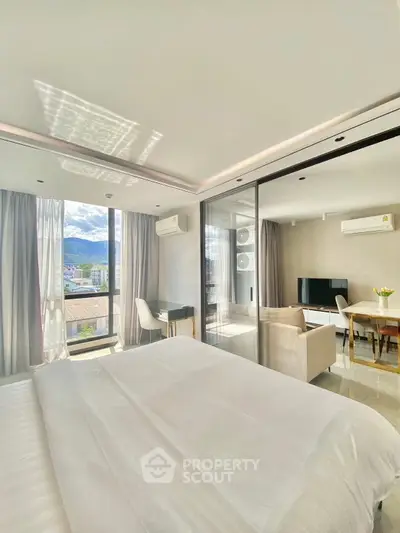 Modern bedroom with mountain view, open layout to living area, and stylish decor.