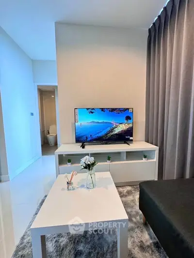 Modern living room with sleek TV setup and elegant decor in a stylish apartment.