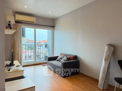Cozy living room with balcony view, featuring modern decor and ample natural light.