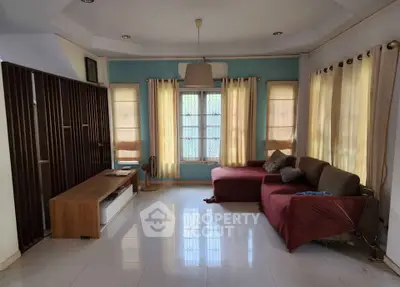 Spacious living room with modern decor and natural light, featuring a cozy sofa and stylish furniture.