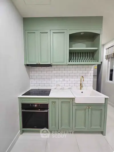 Charming kitchen with mint green cabinets and modern appliances, perfect for culinary enthusiasts.