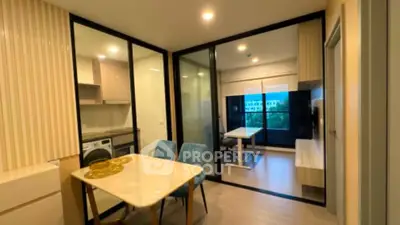 Modern apartment interior with open layout dining and living area, featuring sleek glass partitions.