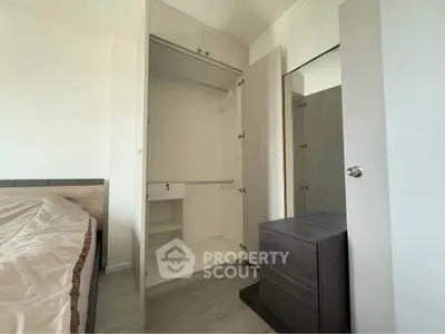 Spacious bedroom with open wardrobe and modern furniture, perfect for stylish living.