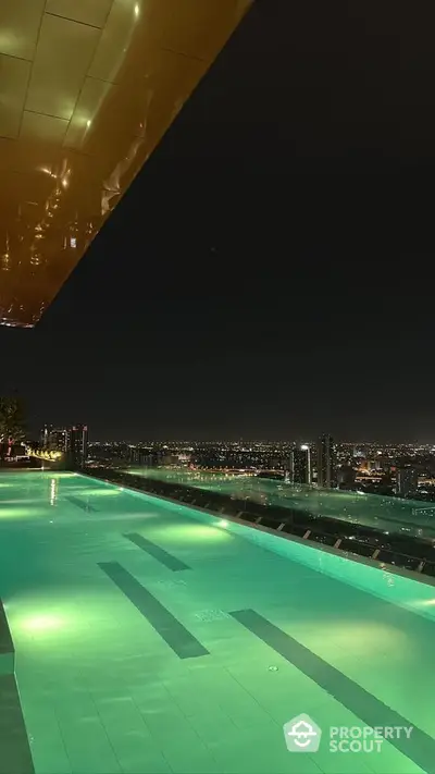 Stunning rooftop pool with breathtaking city skyline view at night