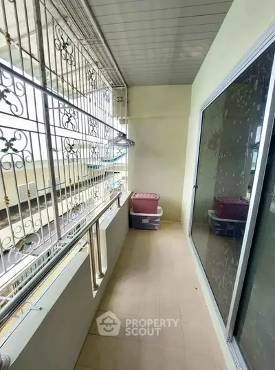 Spacious balcony with sliding glass doors and decorative railing in a modern apartment.