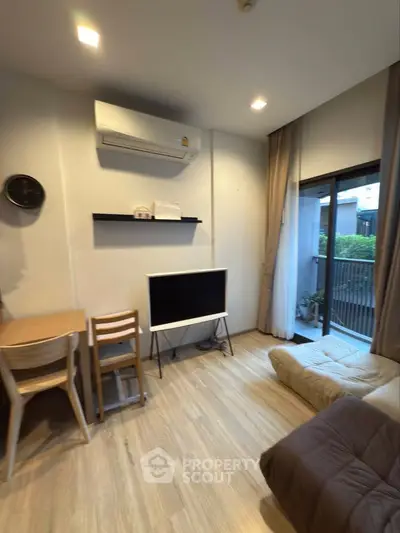 Modern living room with air conditioning, TV, and balcony access in a stylish apartment.