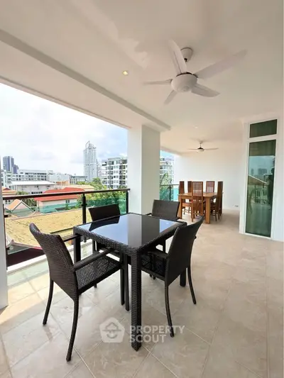 Spacious balcony with modern outdoor dining set and city view, perfect for entertaining and relaxation.