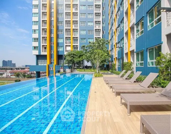 Luxurious apartment complex with stunning outdoor pool and sun loungers.