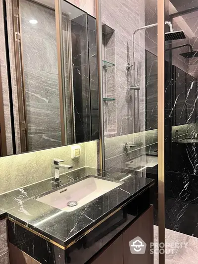 Luxurious modern bathroom with sleek black marble finishes and elegant fixtures.