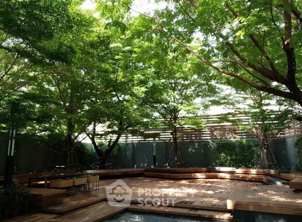 Serene garden area with lush trees and wooden deck, perfect for relaxation.