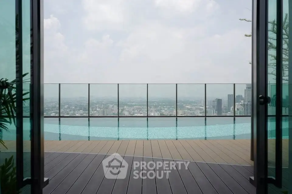 Stunning rooftop pool with panoramic city view and glass railing.