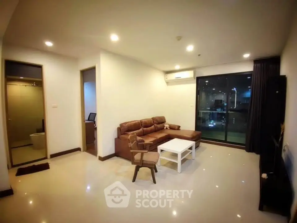 Spacious modern living room with leather sofa and city view balcony