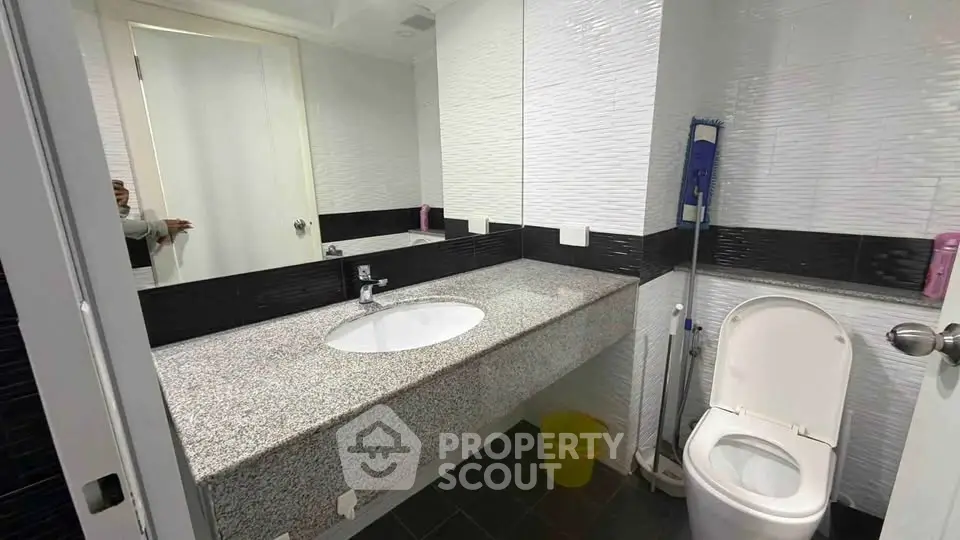 Modern bathroom with sleek design and granite countertop in a contemporary home.