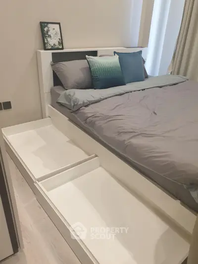 Modern bedroom with sleek white furniture and stylish bedding