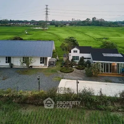 Charming countryside property with modern farmhouse and lush green fields, perfect for serene living.
