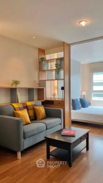 Modern living room with cozy sofa and stylish decor leading to a bright bedroom.