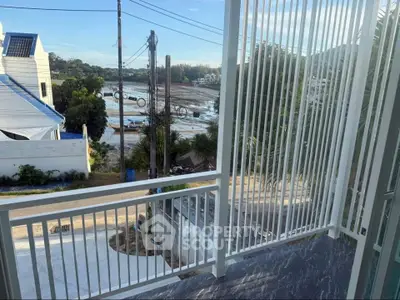 Stunning balcony view overlooking serene waterfront and lush greenery, perfect for relaxation and enjoying nature.