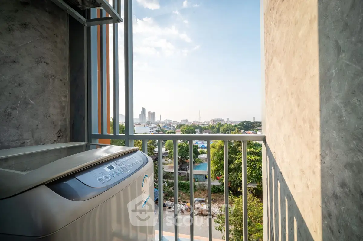 Spacious balcony with modern washing machine overlooking a scenic cityscape, perfect for urban living with a touch of nature.