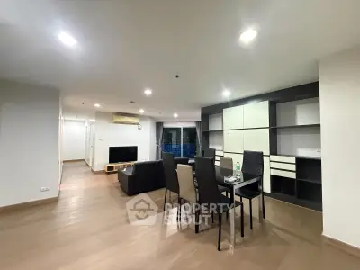 Spacious modern living room with dining area and sleek furniture in open layout apartment.