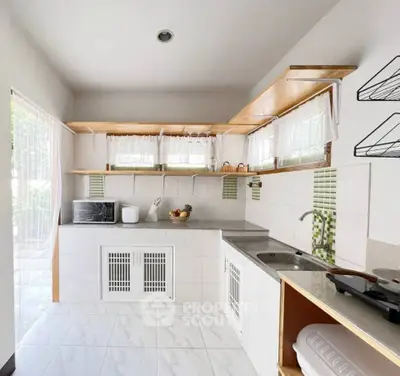 Charming kitchen with open layout and modern appliances, featuring ample natural light and stylish decor.