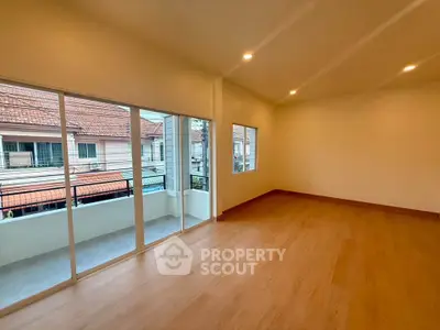 Spacious empty room with large windows and balcony view, perfect for customization.