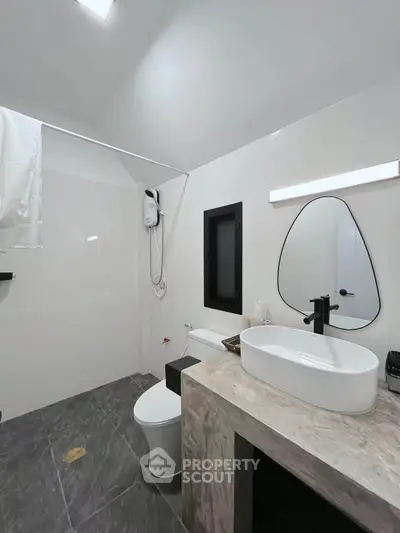 Modern bathroom with sleek design, featuring a stylish mirror and contemporary fixtures.