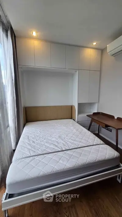 Modern bedroom with built-in storage and natural light in a stylish apartment.