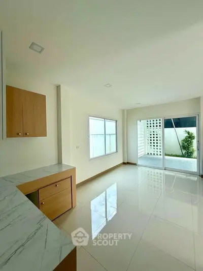 Spacious modern living room with large windows and marble countertops